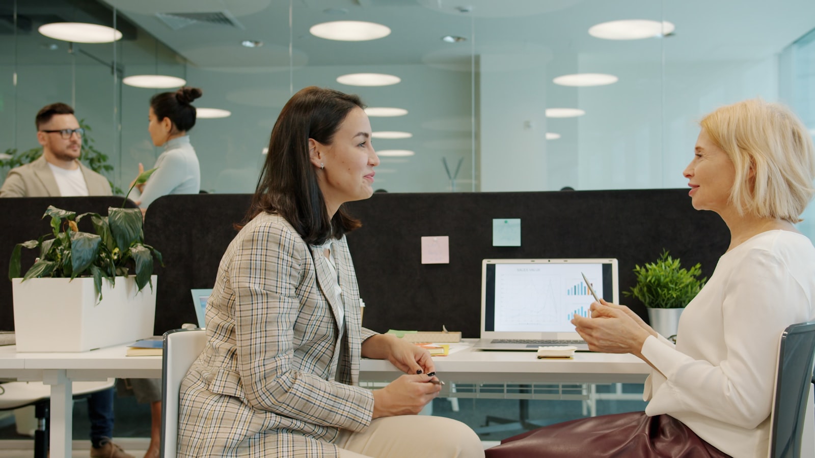 An HR consultant in conversation with a manager at an office desk